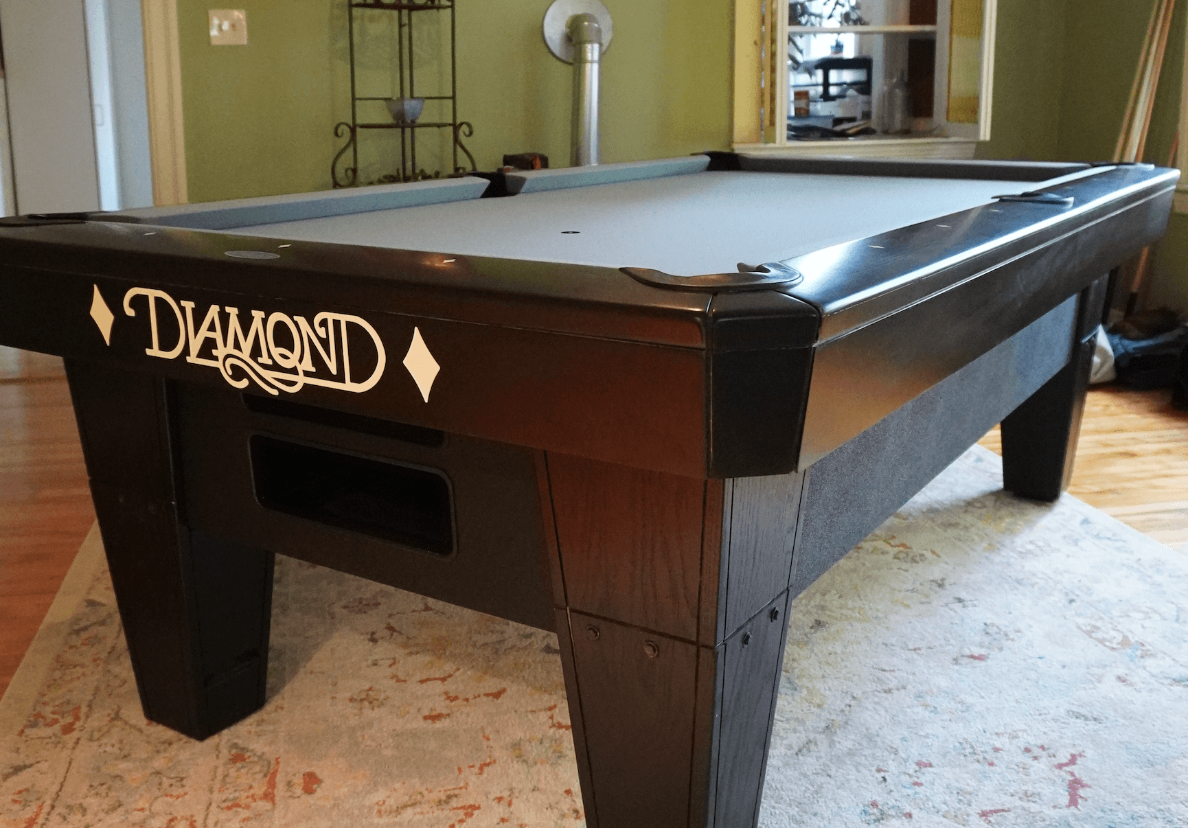 Black Diamond pool table with gray cloth in a green-walled game room