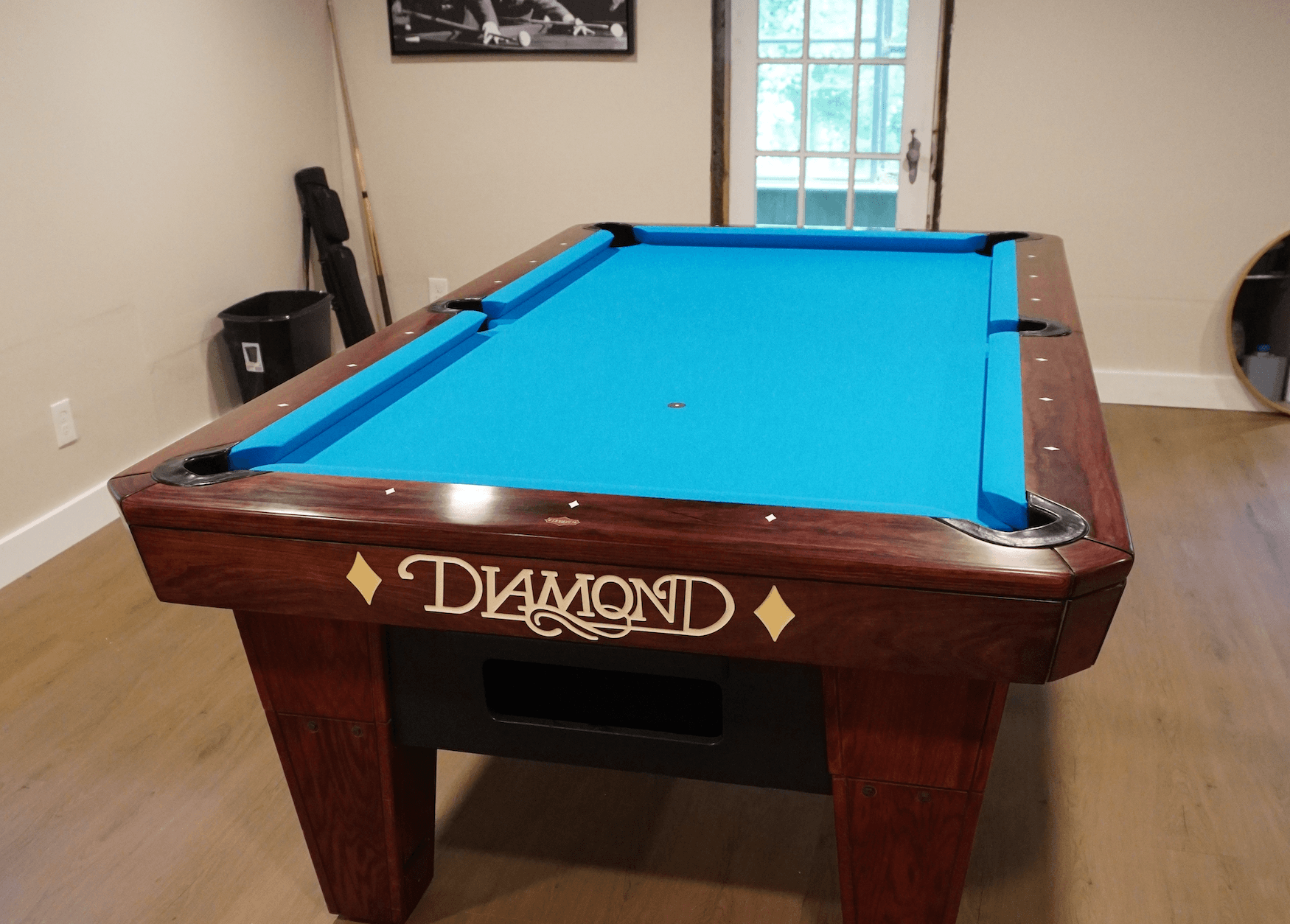 Brown Diamond pool table with light blue cloth in a home game room