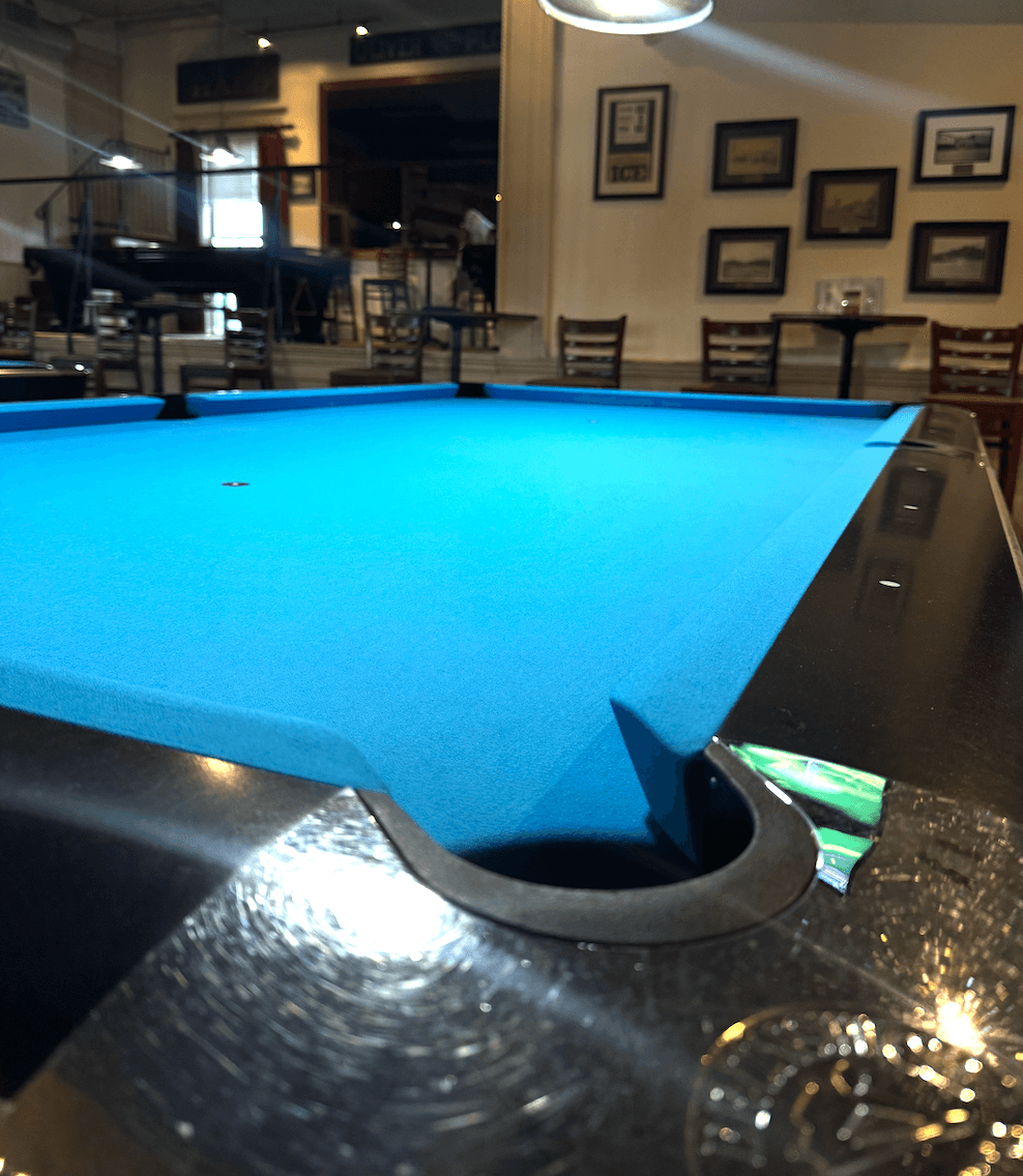 Row of Brunswick Gold Crown tables in Tournament Blue at The Billiards Café