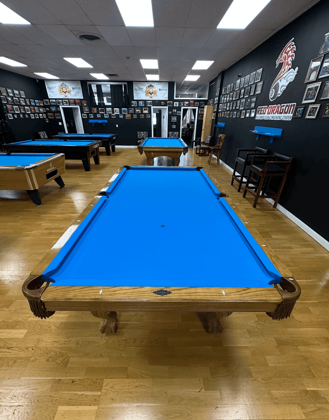 Room full of blue-felt tournament tables at Red Dragon Billiards