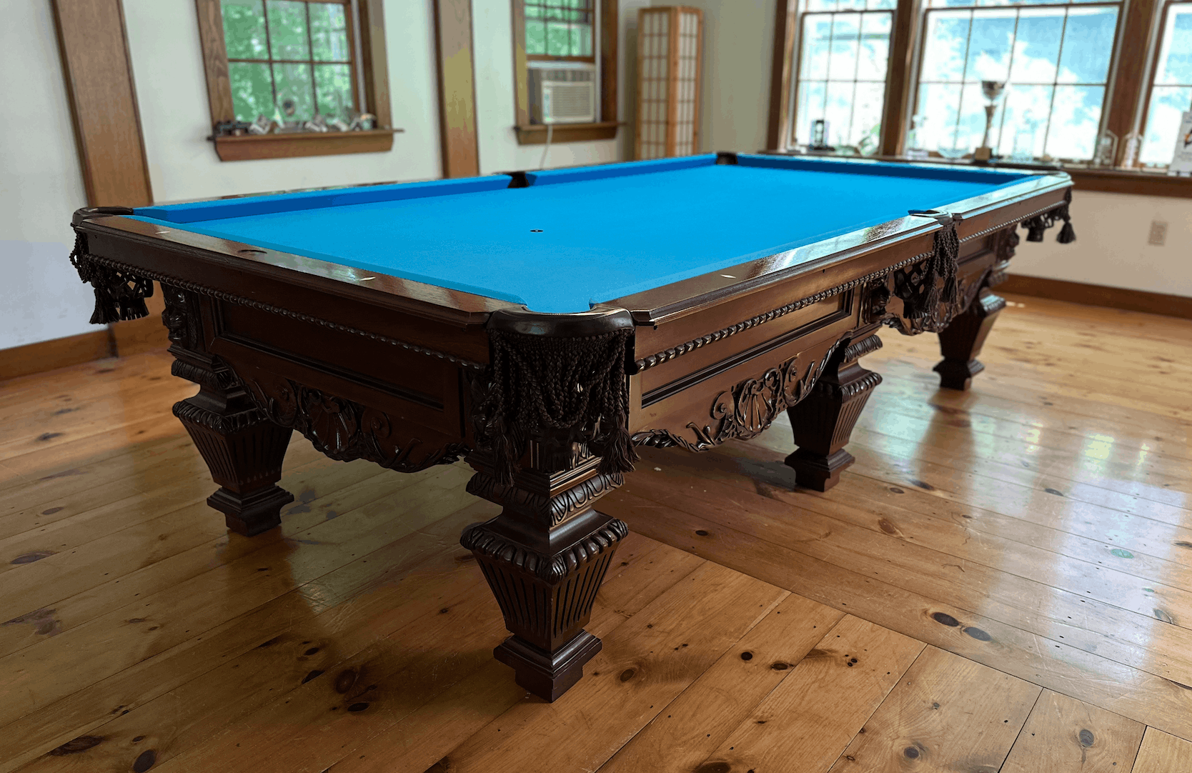 Ornate carved antique table with blue cloth on a wood floor