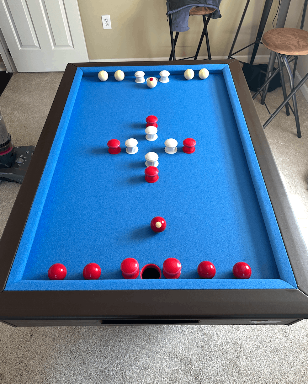 Bumper pool table set up with red and white pegs