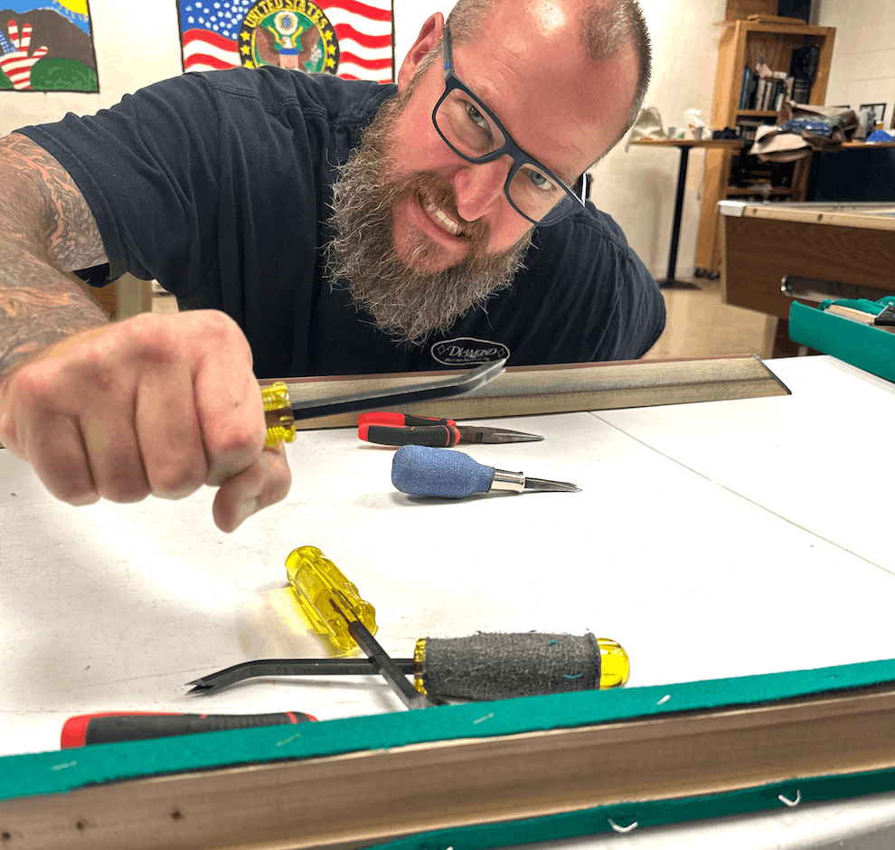 Master Billiards technician smiling while installing a table rail