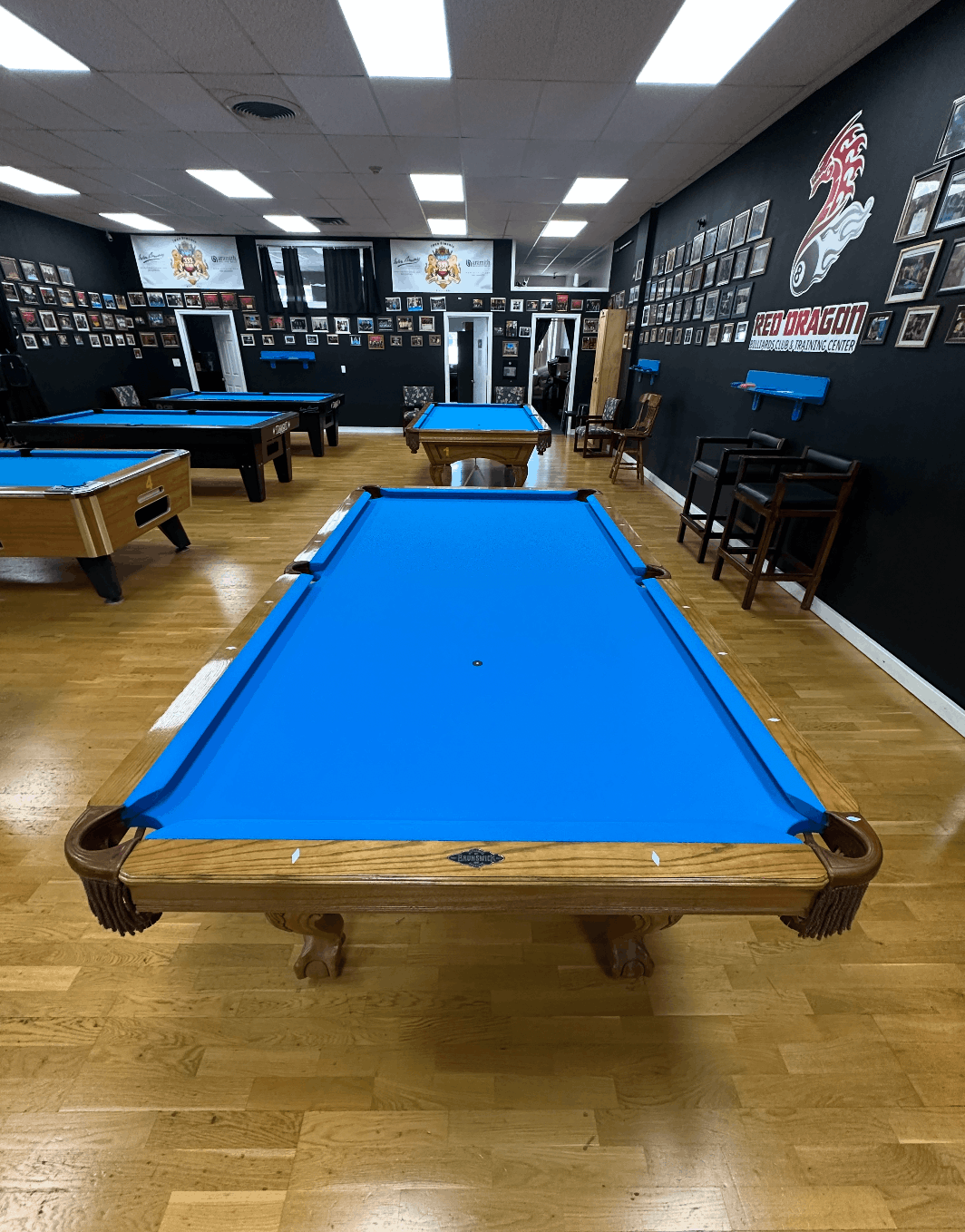 Room full of blue-felt tournament tables at Red Dragon Billiards